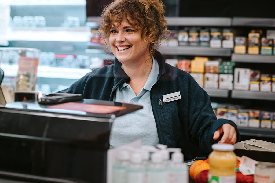 Retail store manager working at POS system with scan data program.